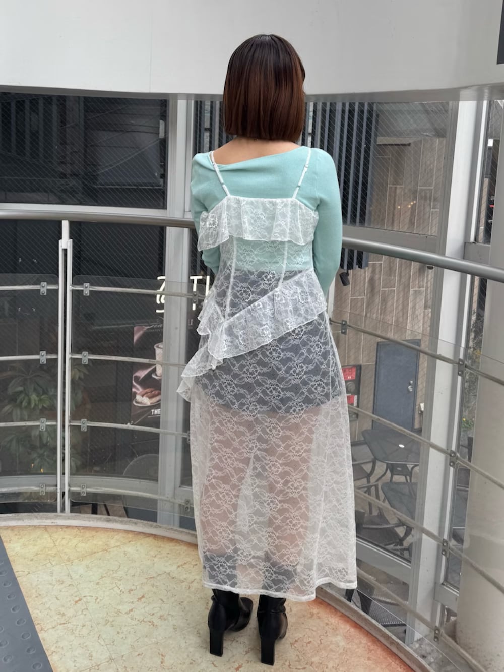 グリーン系のニット/セーター、ブルー系のデニムパンツ、ブラック系のブーツを着用したレディースの冬コーディネートの4枚目の写真