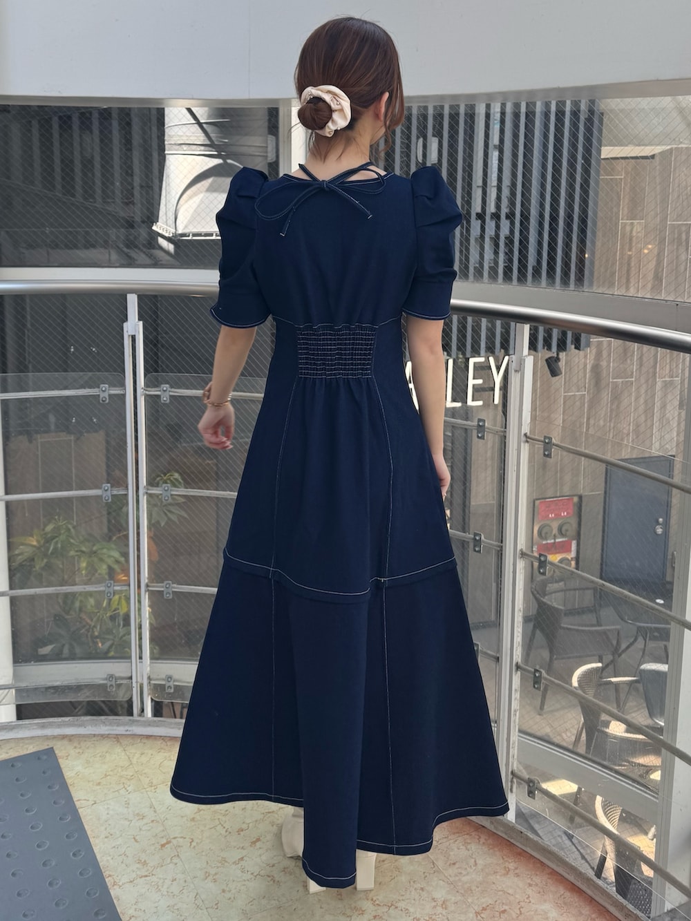 ブルー系のワンピース、ホワイト系のブーツを着用したレディースの春コーディネートの3枚目の写真