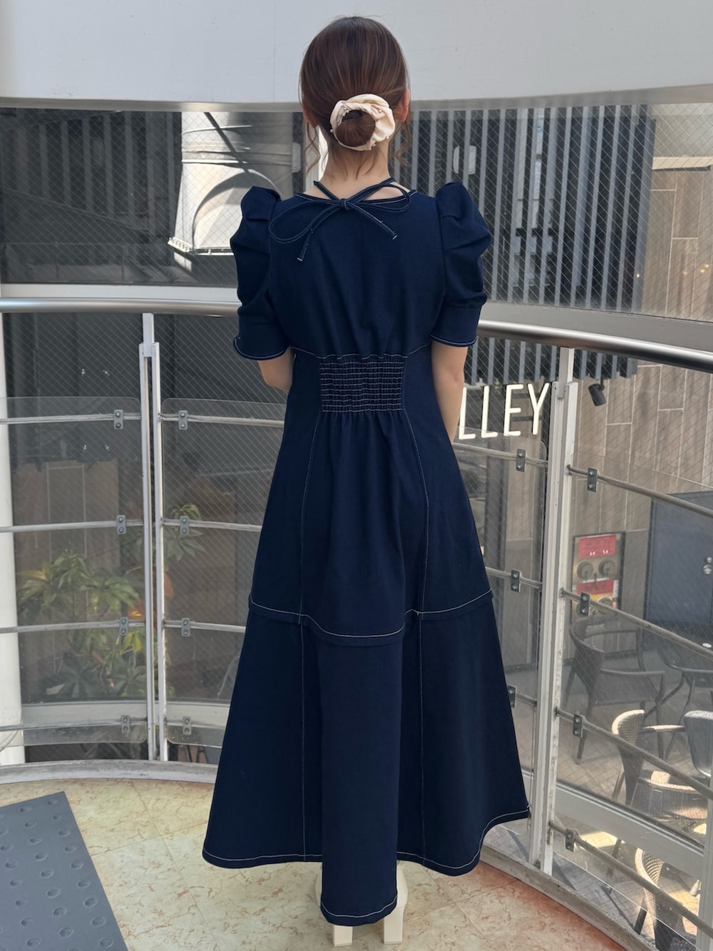 ブルー系のワンピース、ホワイト系のブーツを着用したレディースの春コーディネートの4枚目の写真