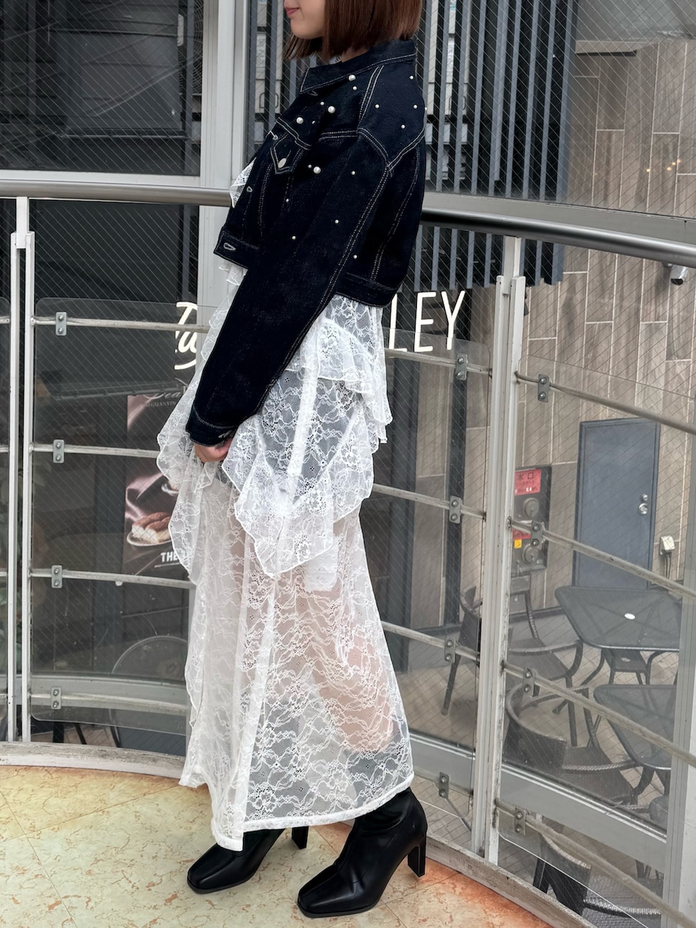 ブルー系のデニムジャケット、ホワイト系のキャミソール、ブルー系のデニムパンツを着用したレディースの冬コーディネートの3枚目の写真