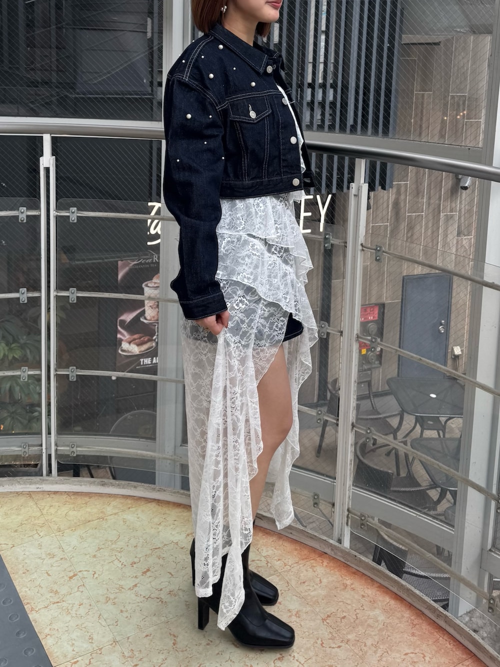 ブルー系のデニムジャケット、ホワイト系のキャミソール、ブルー系のデニムパンツを着用したレディースの冬コーディネートの5枚目の写真