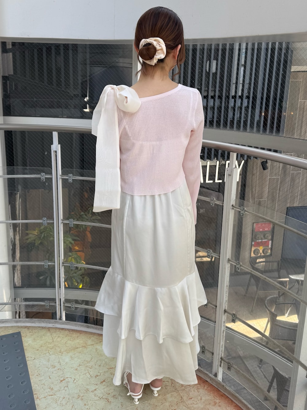 ホワイト系のワンピース、ピンク系のカーディガン/ボレロ、ホワイト系のパンプスを着用したレディースの春コーディネートの4枚目の写真