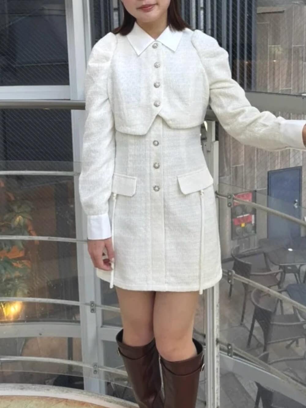 ホワイト系のワンピース、ブラウン系のブーツを着用したレディースの冬コーディネートの4枚目の写真