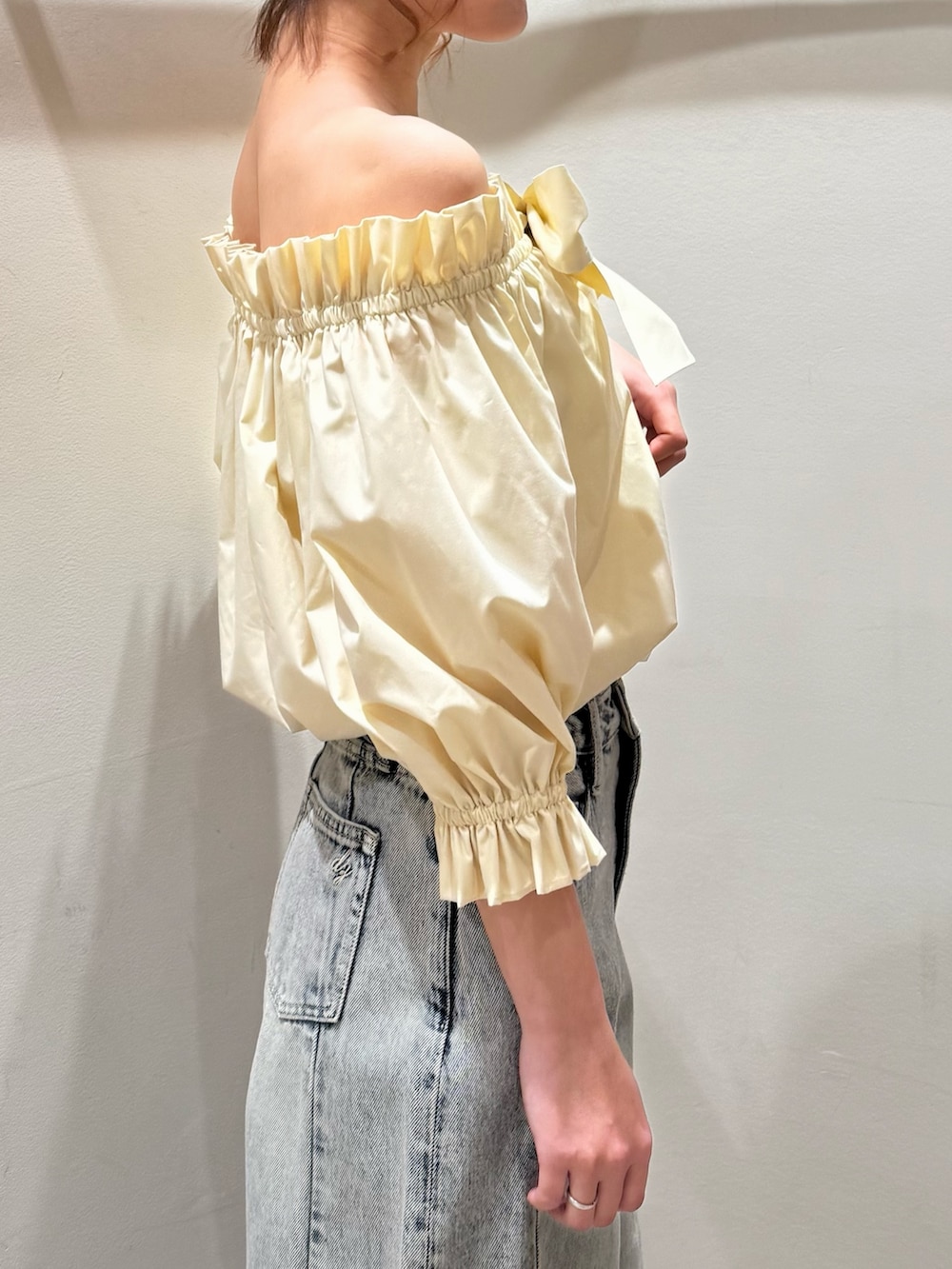 ブルー系のデニムパンツ、ホワイト系のパンプス、イエロー系のシャツ/ブラウスを着用したレディースの春コーディネートの6枚目の写真