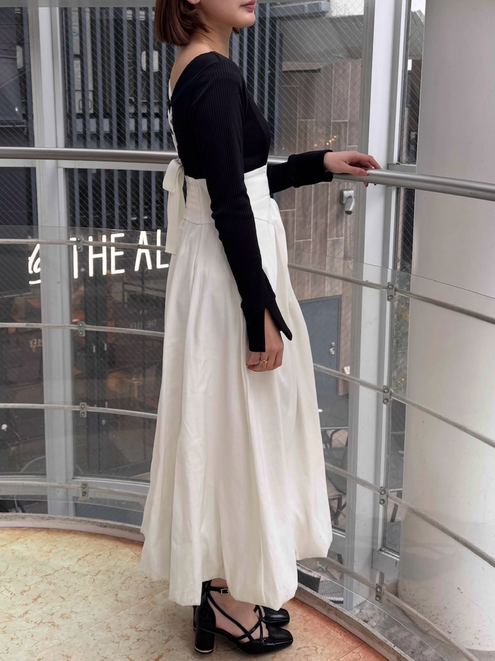 ホワイト系のワンピース、ブラック系のサンダルを着用したレディースの冬コーディネートの5枚目の写真