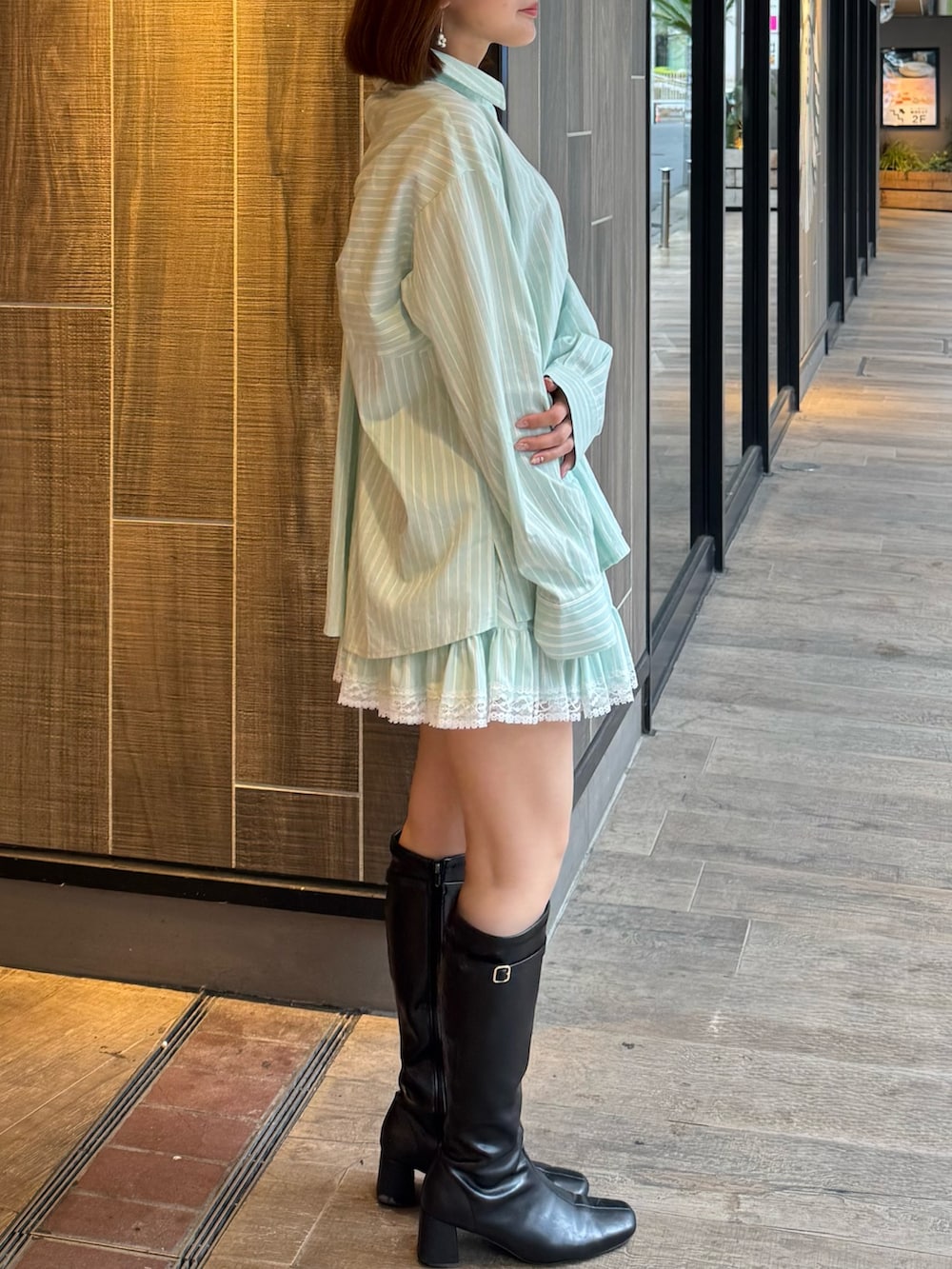 グリーン系のシャツ/ブラウス、グリーン系のスカート、ブラック系のブーツを着用したレディースの春コーディネートの4枚目の写真