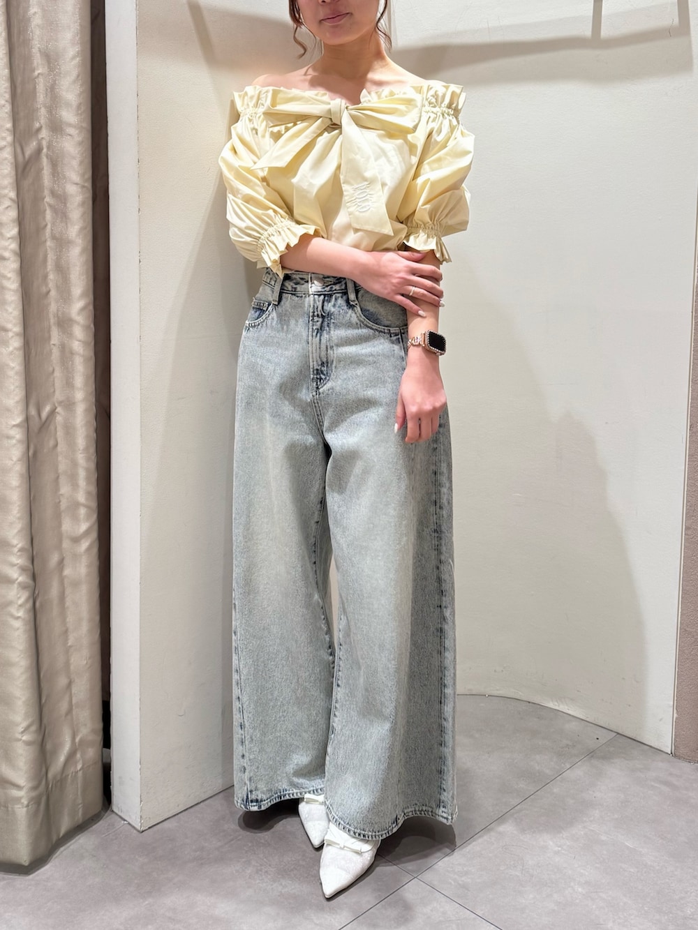 ブルー系のデニムパンツ、ホワイト系のパンプス、イエロー系のシャツ/ブラウスを着用したレディースの春コーディネートの2枚目の写真