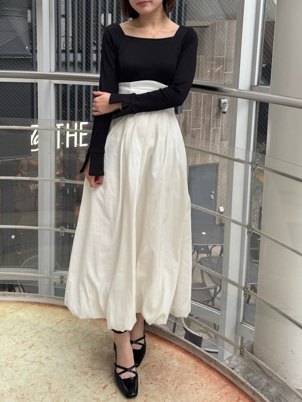 ホワイト系のワンピース、ブラック系のサンダルを着用したレディースの冬コーディネートの2枚目の写真