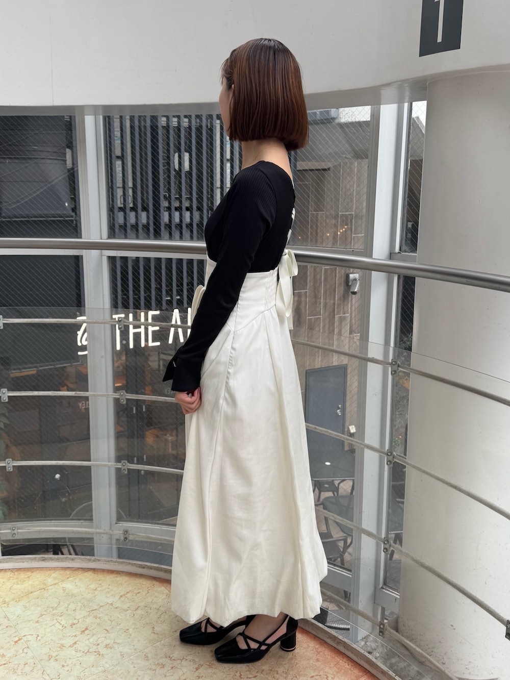 ホワイト系のワンピース、ブラック系のサンダルを着用したレディースの冬コーディネートの3枚目の写真