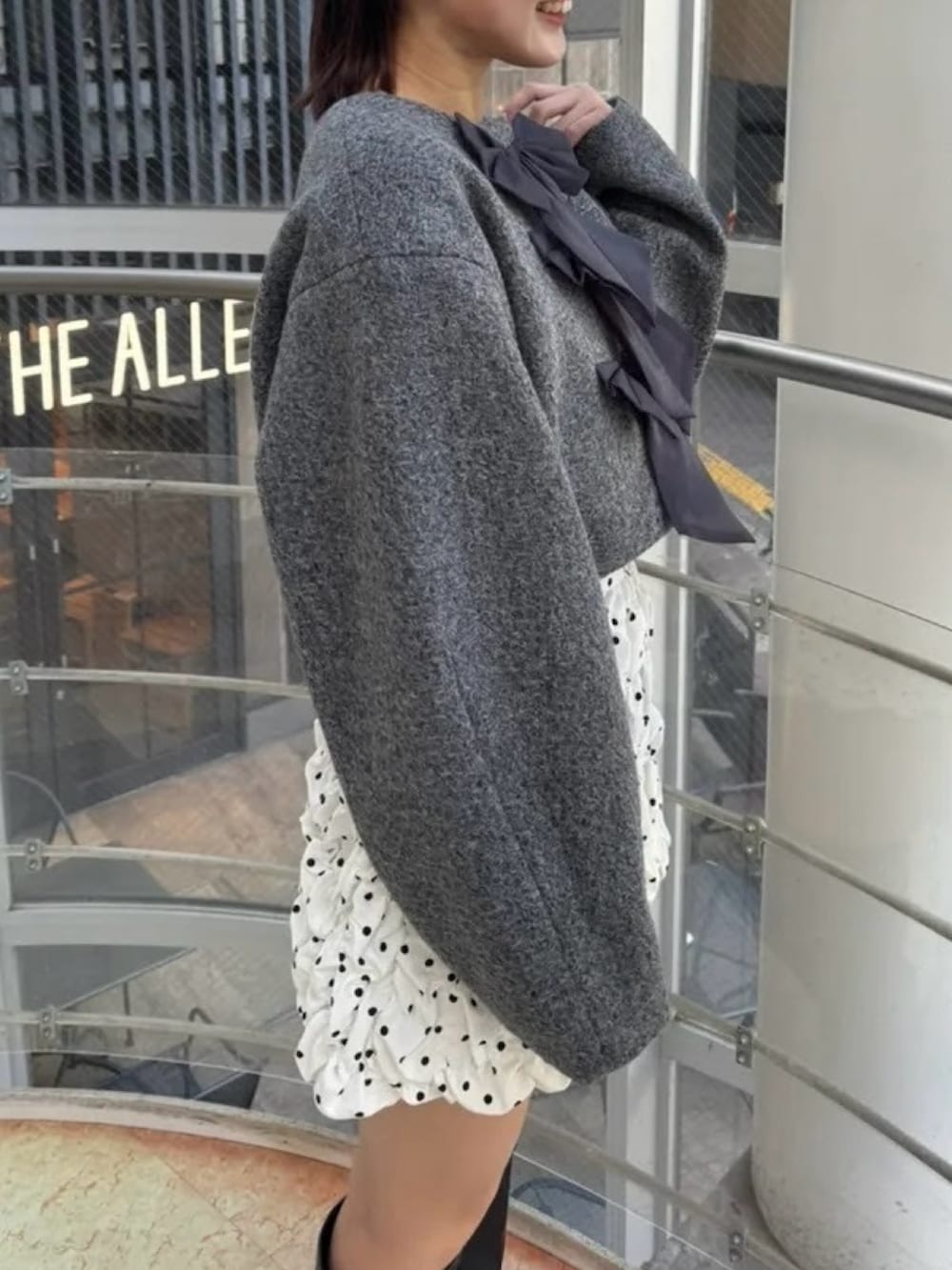 ホワイト系のスカート、グレー系のブルゾン、ブラック系のブーツを着用したレディースの冬コーディネートの7枚目の写真