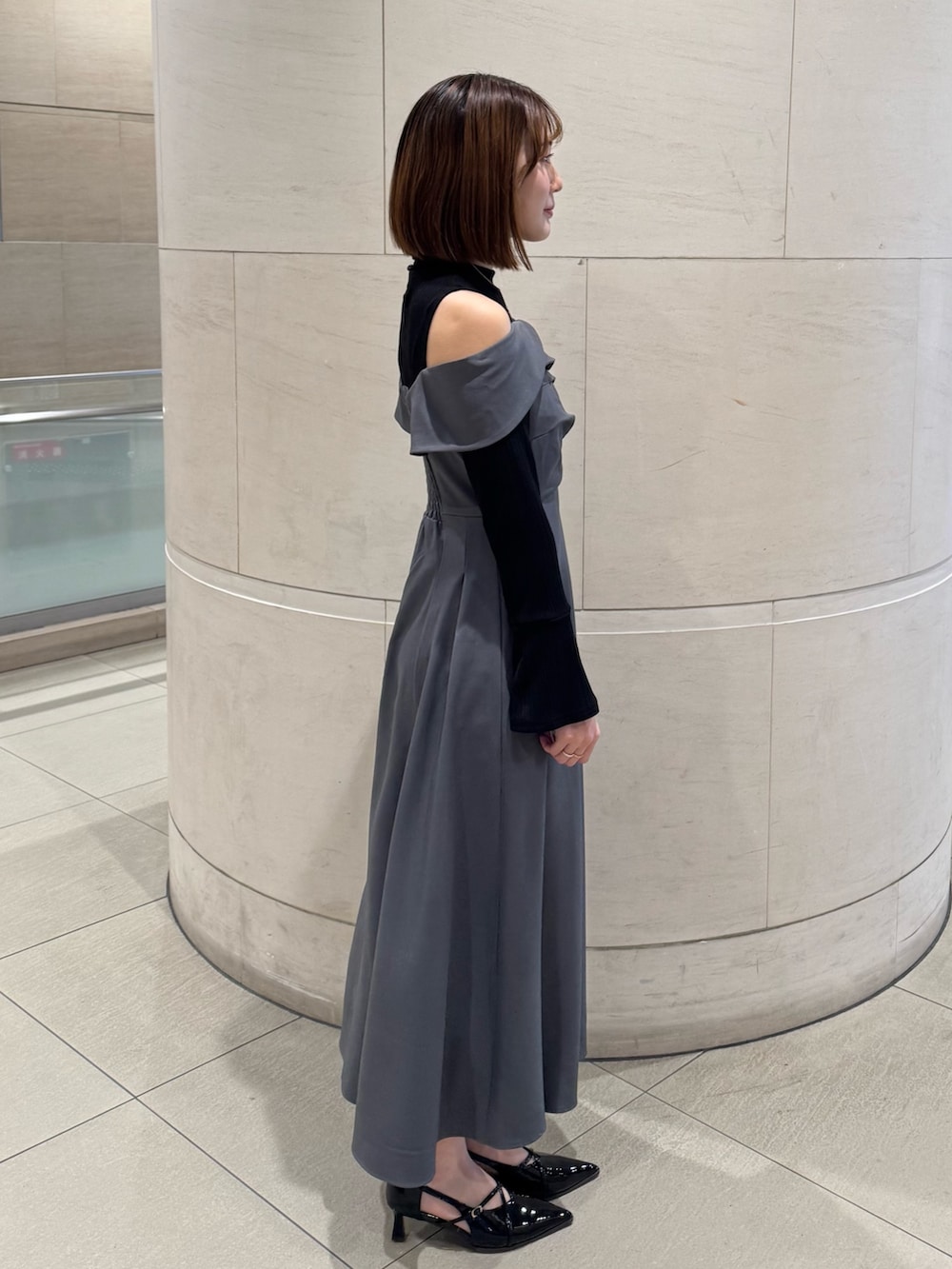 グレー系のワンピース、ブラック系のパンプスを着用したレディースの冬コーディネートの5枚目の写真