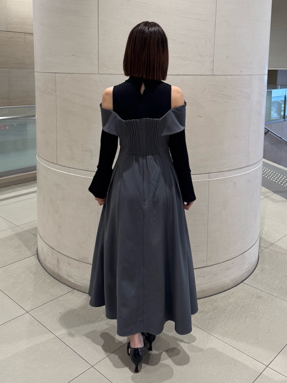 グレー系のワンピース、ブラック系のパンプスを着用したレディースの冬コーディネートの4枚目の写真