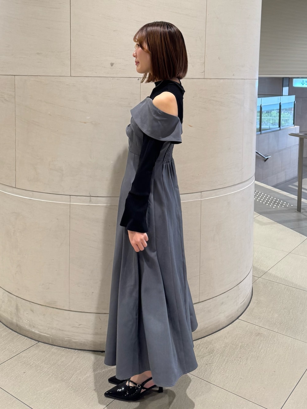 グレー系のワンピース、ブラック系のパンプスを着用したレディースの冬コーディネートの3枚目の写真