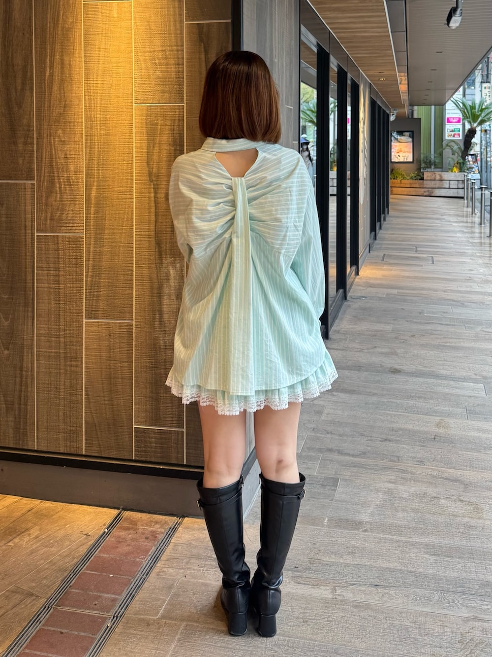 グリーン系のシャツ/ブラウス、グリーン系のスカート、ブラック系のブーツを着用したレディースの春コーディネートの2枚目の写真