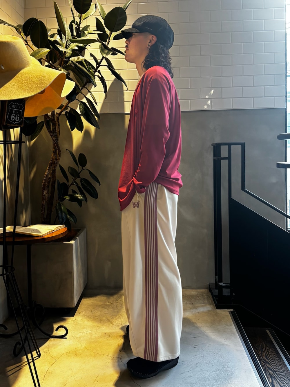 レッド系のニット/セーター、ホワイト系のTシャツ/カットソー、ベージュ系のパンツを着用したメンズの夏コーディネートの4枚目の写真