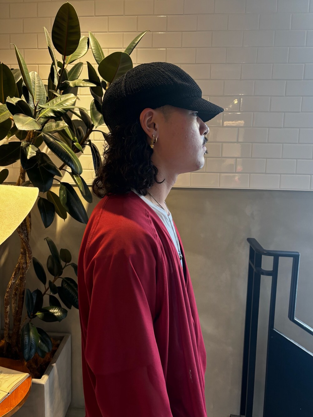 レッド系のニット/セーター、ホワイト系のTシャツ/カットソー、ベージュ系のパンツを着用したメンズの夏コーディネートの6枚目の写真