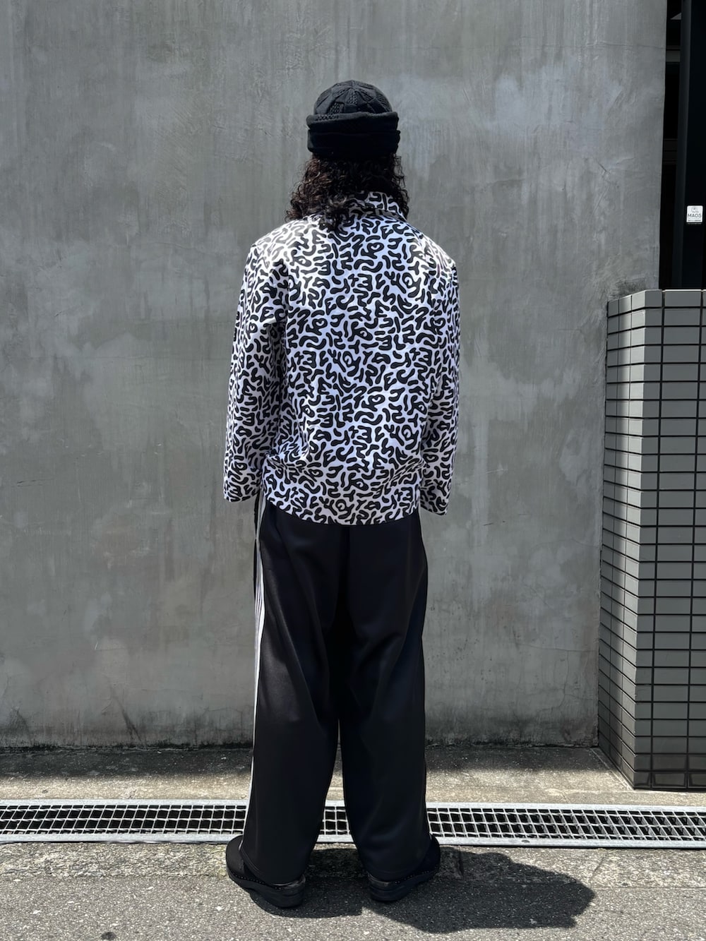 ホワイト系のシャツ/ブラウス、ブラック系のパンツ、ブラック系のニットキャップ/ビーニーを着用したメンズの夏コーディネートの4枚目の写真