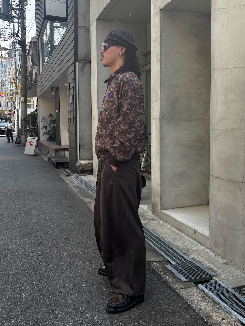 ブラウン系のブルゾン、ブラウン系のその他パンツ、ブラック系のモカシン/デッキシューズを着用したメンズの夏コーディネートの3枚目の写真