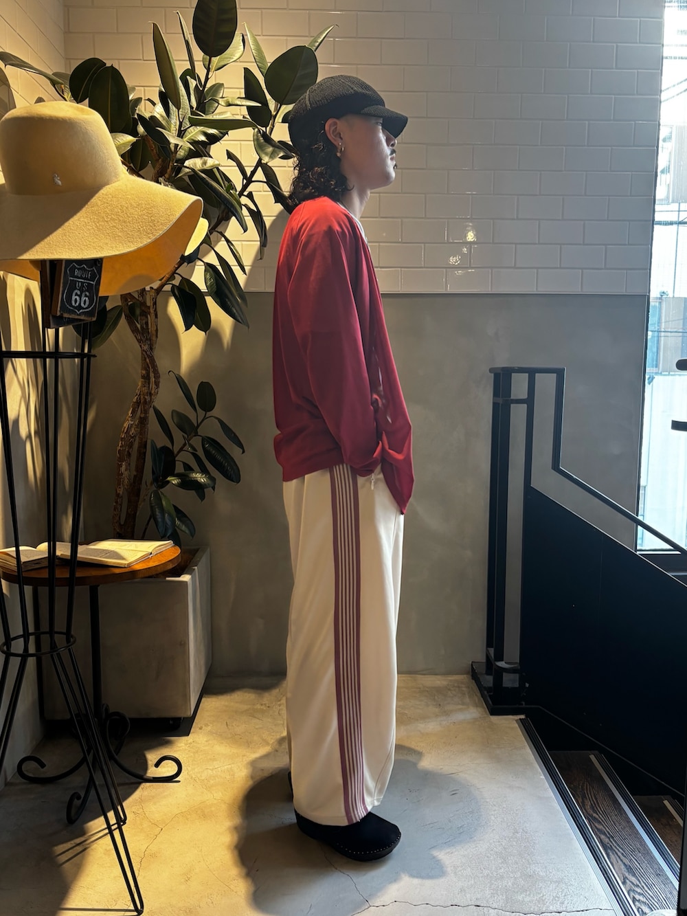 レッド系のニット/セーター、ホワイト系のTシャツ/カットソー、ベージュ系のパンツを着用したメンズの夏コーディネートの3枚目の写真