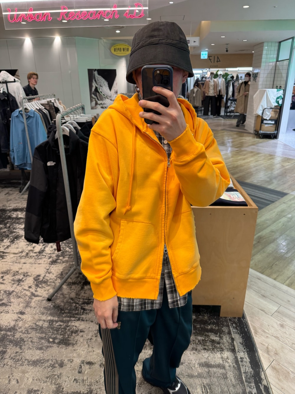 オレンジ系のパーカー、ブラック系のシャツ/ブラウス、グリーン系のその他パンツを着用したメンズの春コーディネートの2枚目の写真