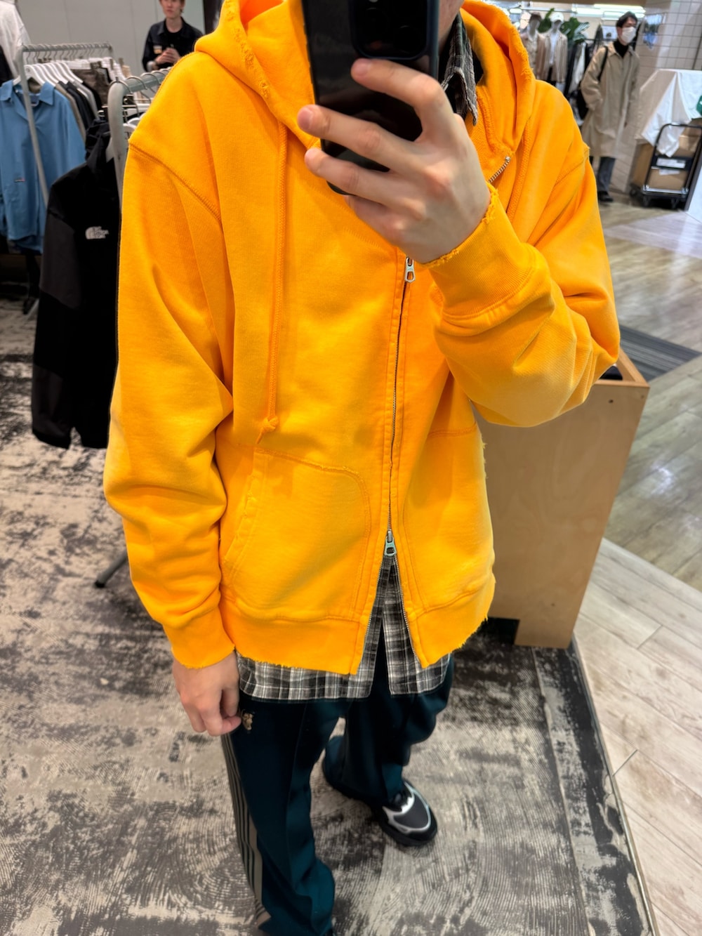 オレンジ系のパーカー、ブラック系のシャツ/ブラウス、グリーン系のその他パンツを着用したメンズの春コーディネートの3枚目の写真