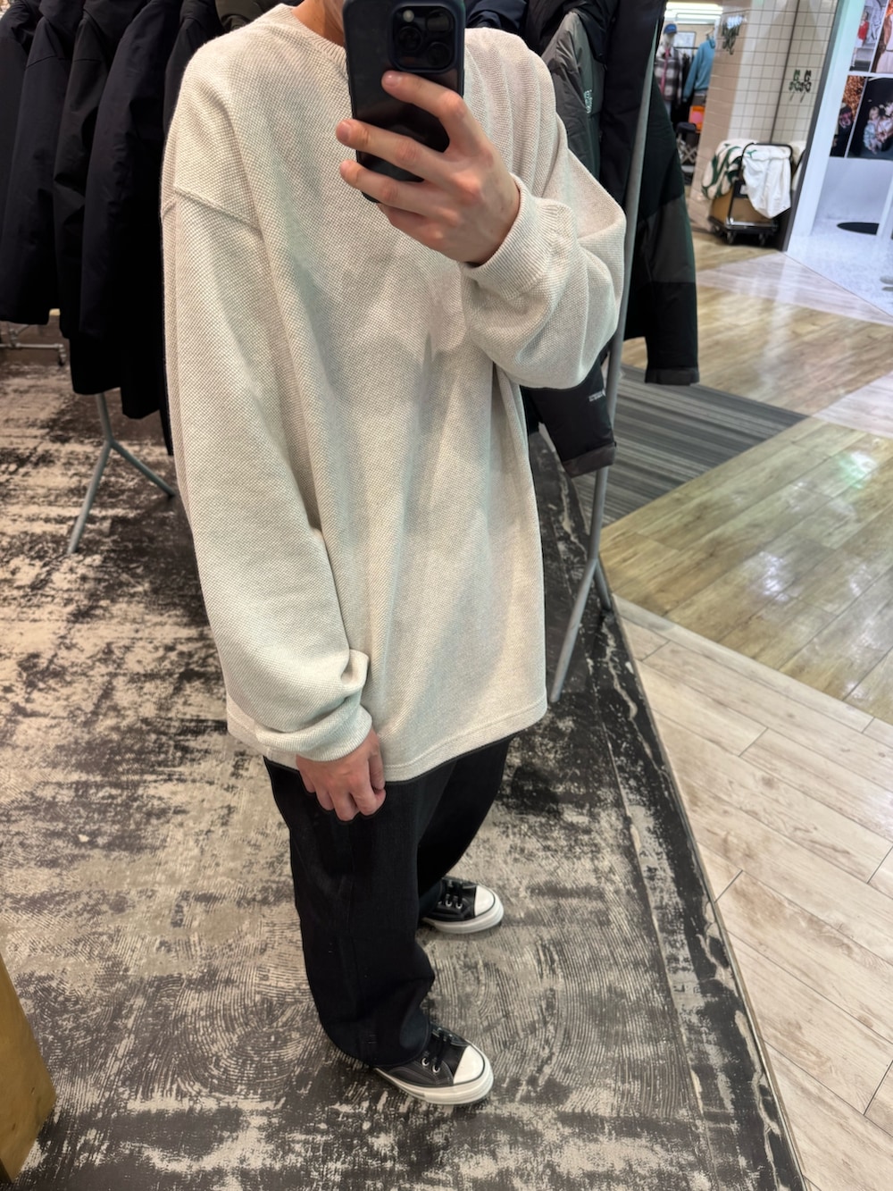 ホワイト系のニット/セーター、ブルー系のデニムパンツ、ブラック系のスニーカーを着用したメンズの冬コーディネートの3枚目の写真