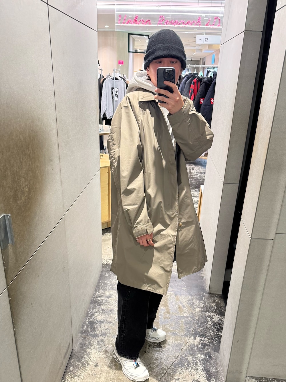 ホワイト系のパーカー、グレー系のステンカラーコート、ブラック系のデニムパンツを着用したメンズの冬コーディネートの2枚目の写真