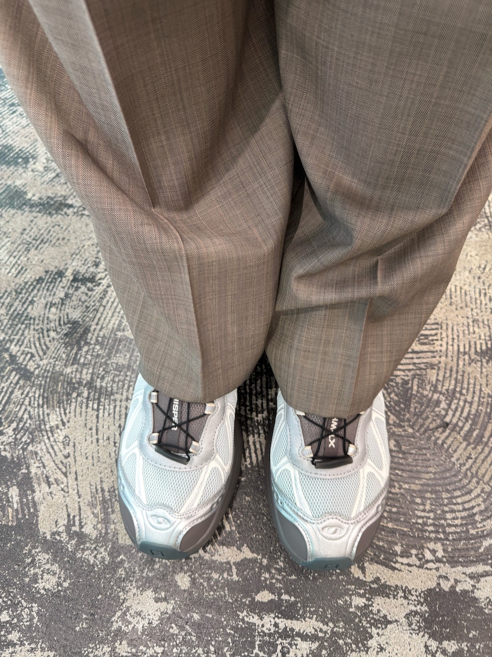 ホワイト系のパーカー、ブラウン系のその他パンツ、シルバー系のスニーカーを着用したメンズの春コーディネートの4枚目の写真