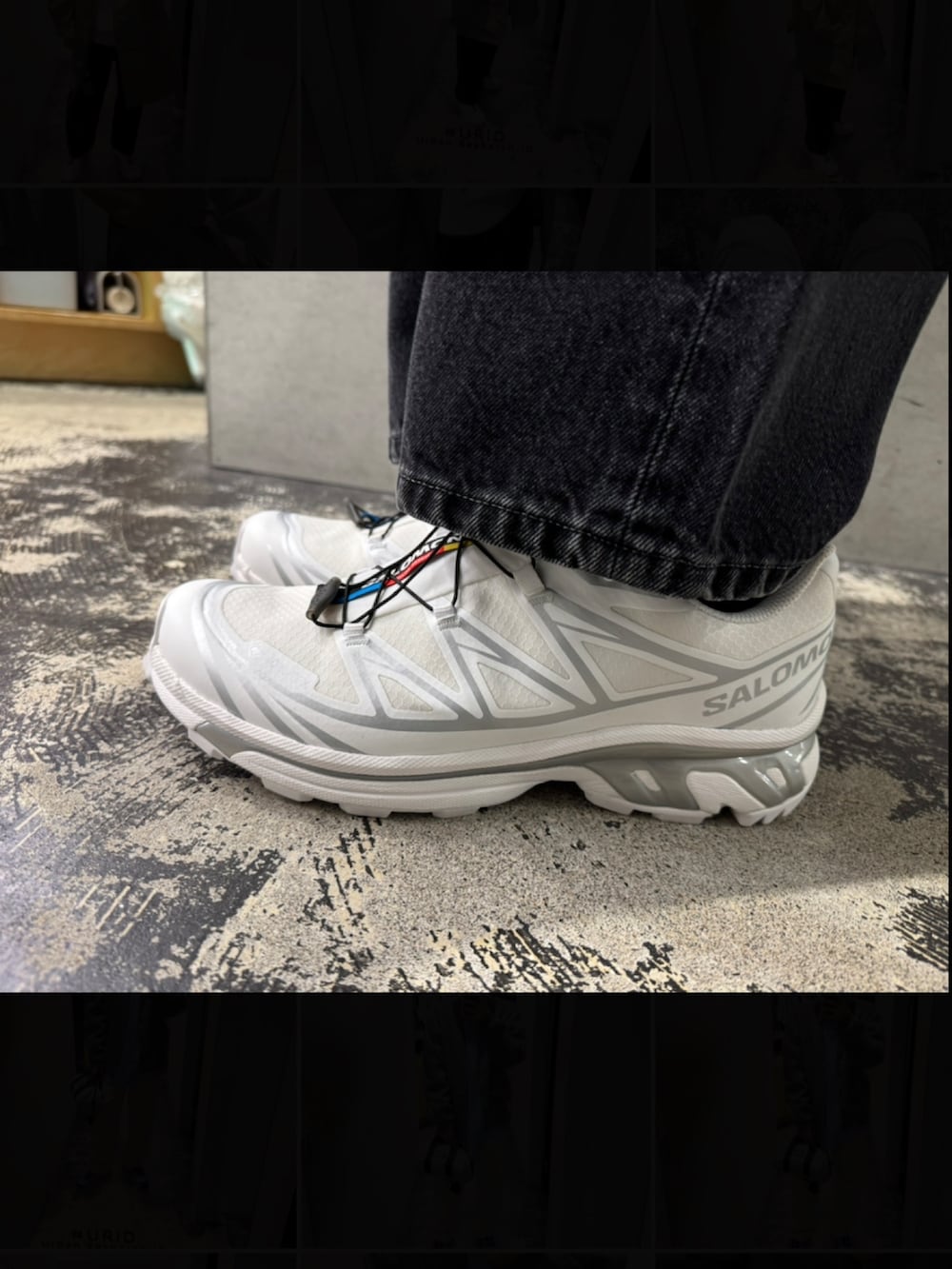 ホワイト系のパーカー、グレー系のステンカラーコート、ブラック系のデニムパンツを着用したメンズの冬コーディネートの6枚目の写真