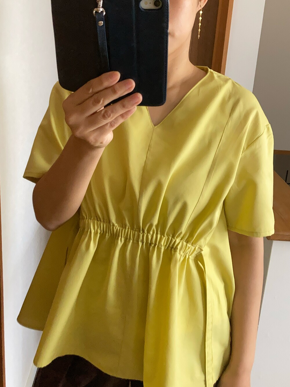 ブラウン系のチノパンツ、イエロー系のTシャツ/カットソー、グレー系のサンダルを着用したレディースの春コーディネートの2枚目の写真