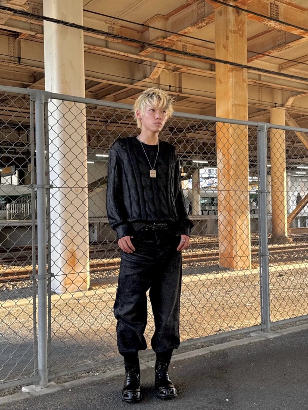 ブラック系のブーツ、ブラック系のニット/セーター、ブラック系のデニムパンツを着用したメンズの秋コーディネートの2枚目の写真