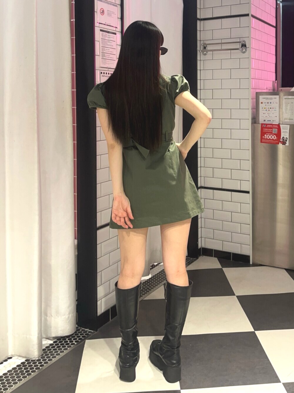 グリーン系のワンピース、ブラック系のサングラスを着用したレディースの春コーディネートの3枚目の写真