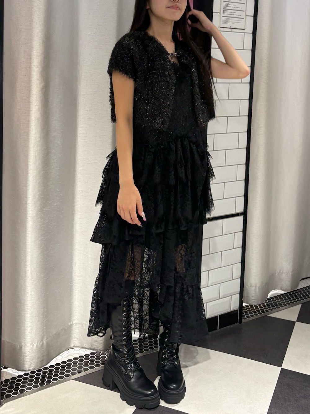 ブラック系のアンサンブル、ブラック系のスカート、ブラック系のブーツを着用したレディースの秋コーディネートの3枚目の写真