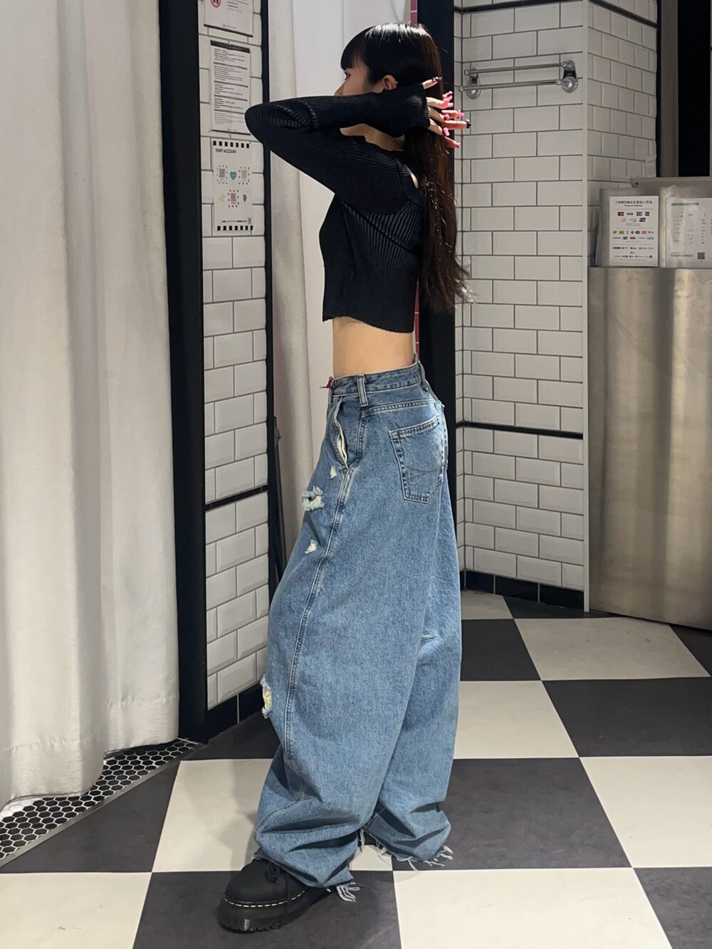 ブルー系のデニムパンツ、ブラック系のニット/セーター、ブラック系のブーツを着用したレディースの春コーディネートの2枚目の写真