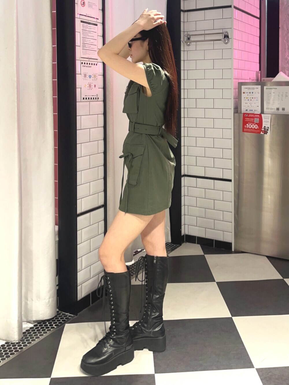 グリーン系のワンピース、ブラック系のサングラスを着用したレディースの春コーディネートの2枚目の写真