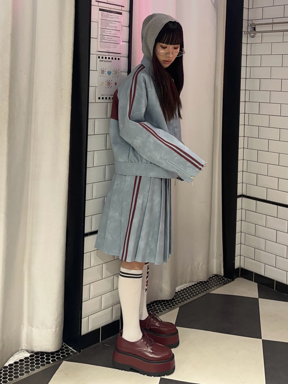 ブルー系のスカート、ブルー系のブルゾン、グレー系のパーカーを着用したレディースの冬コーディネートの2枚目の写真