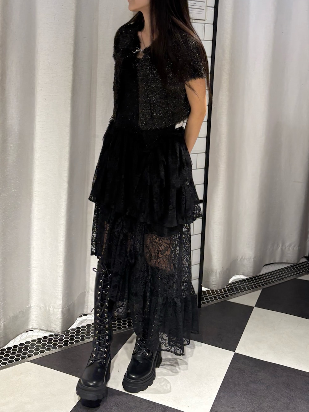 ブラック系のアンサンブル、ブラック系のスカート、ブラック系のブーツを着用したレディースの秋コーディネートの2枚目の写真