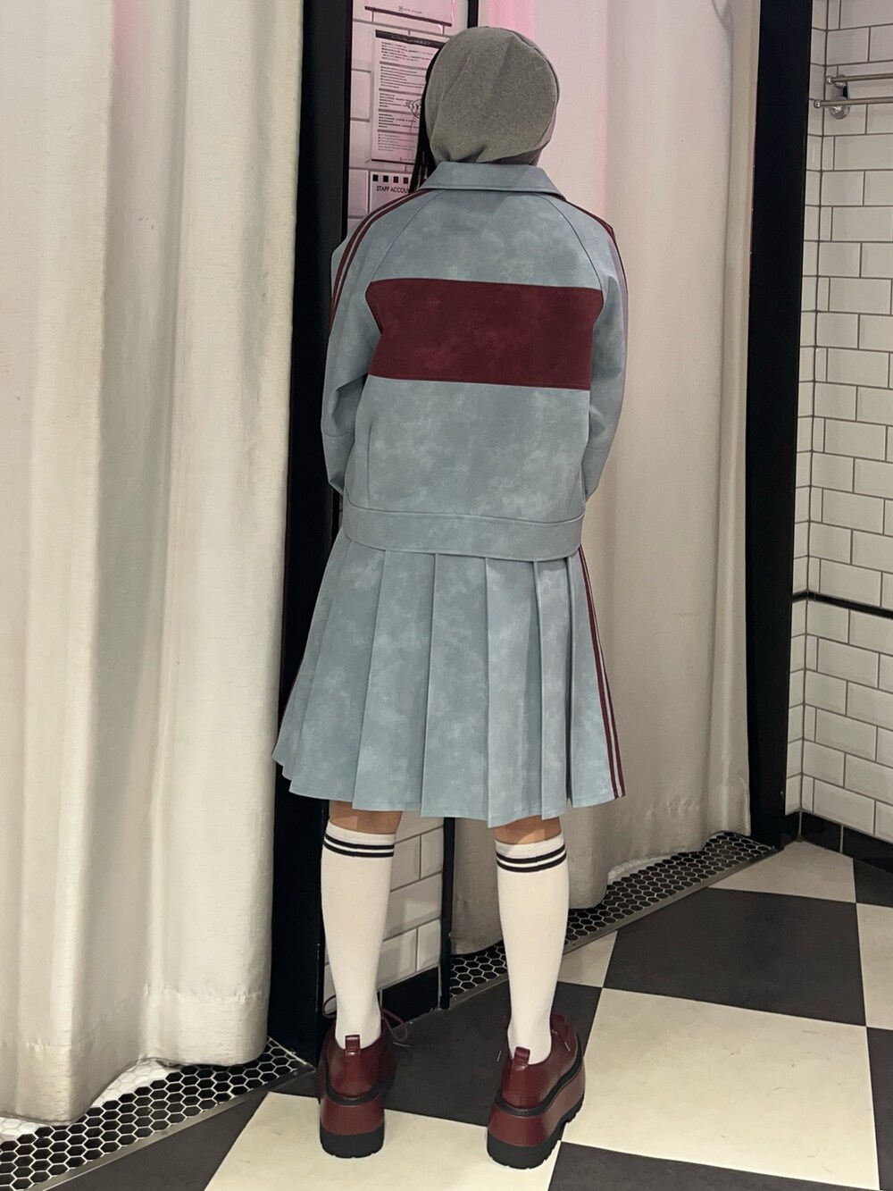 ブルー系のスカート、ブルー系のブルゾン、グレー系のパーカーを着用したレディースの冬コーディネートの3枚目の写真