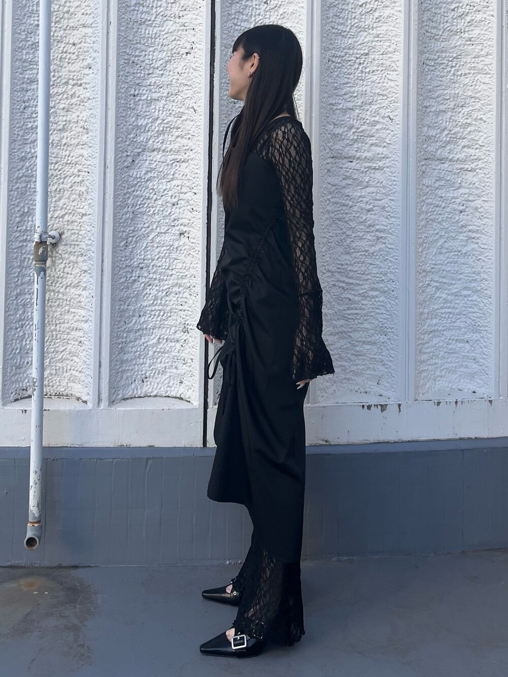 ブラック系のワンピース、ブラック系のTシャツ/カットソー、ブラック系のパンプスを着用したレディースの冬コーディネートの2枚目の写真