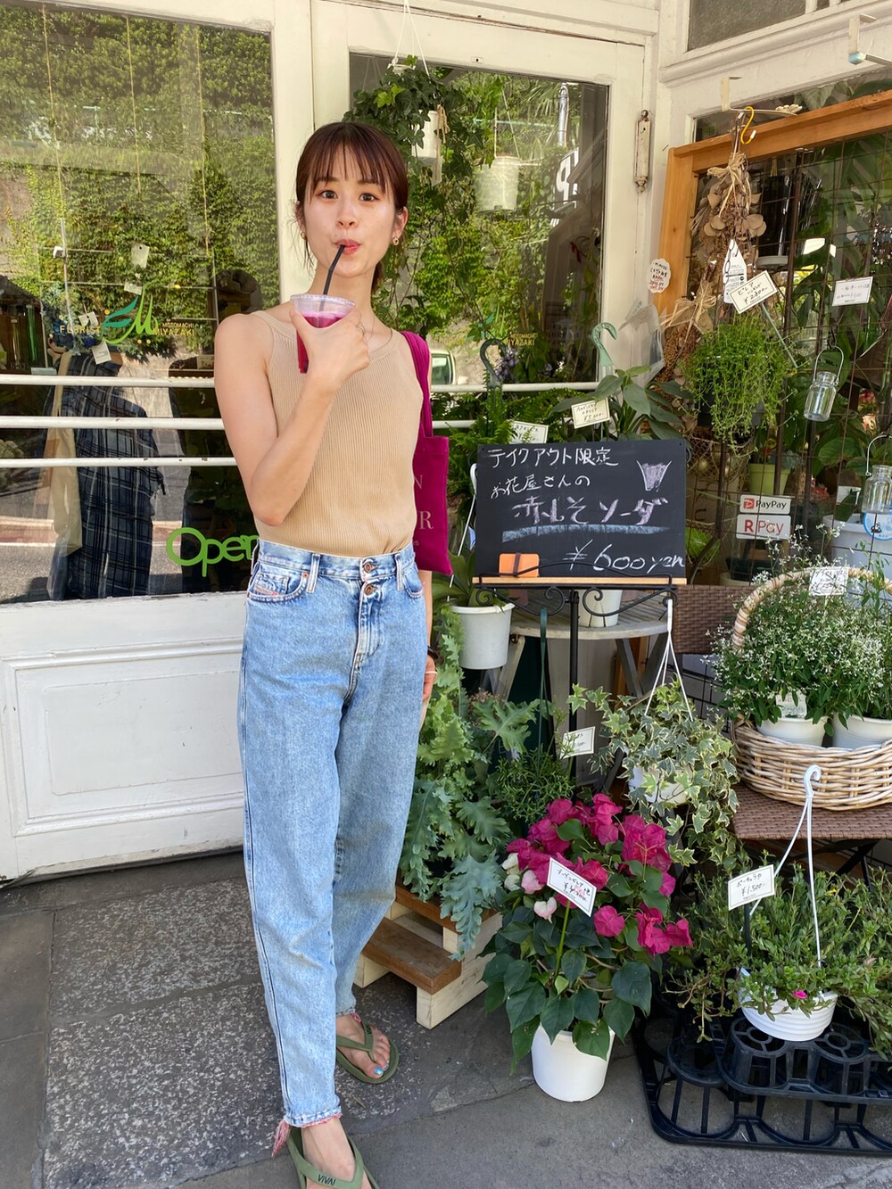 ブルー系のデニムパンツ、ピンク系のトートバッグを着用したレディースの夏コーディネートの2枚目の写真