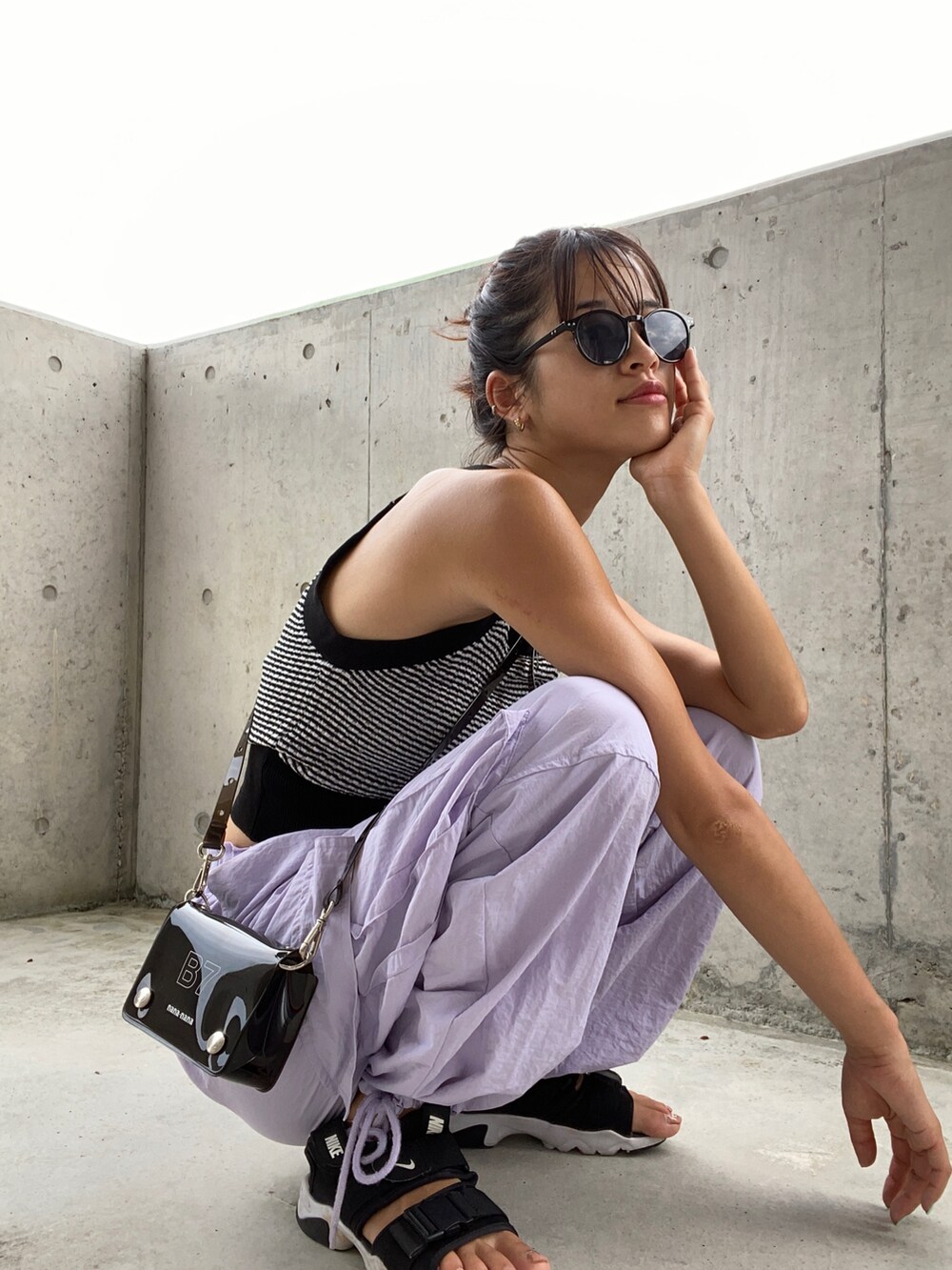 ブラック系のサンダル、パープル系のカーゴパンツ、ブラック系のトップスを着用したレディースの夏コーディネートの2枚目の写真