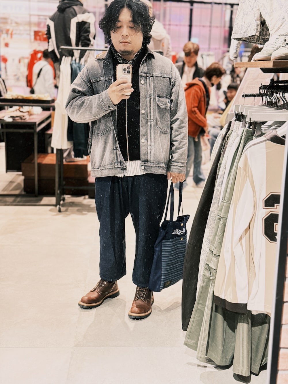 ブルー系のデニムパンツ、ブラウン系のブーツ、ブラック系のベストを着用したメンズの冬コーディネートの3枚目の写真