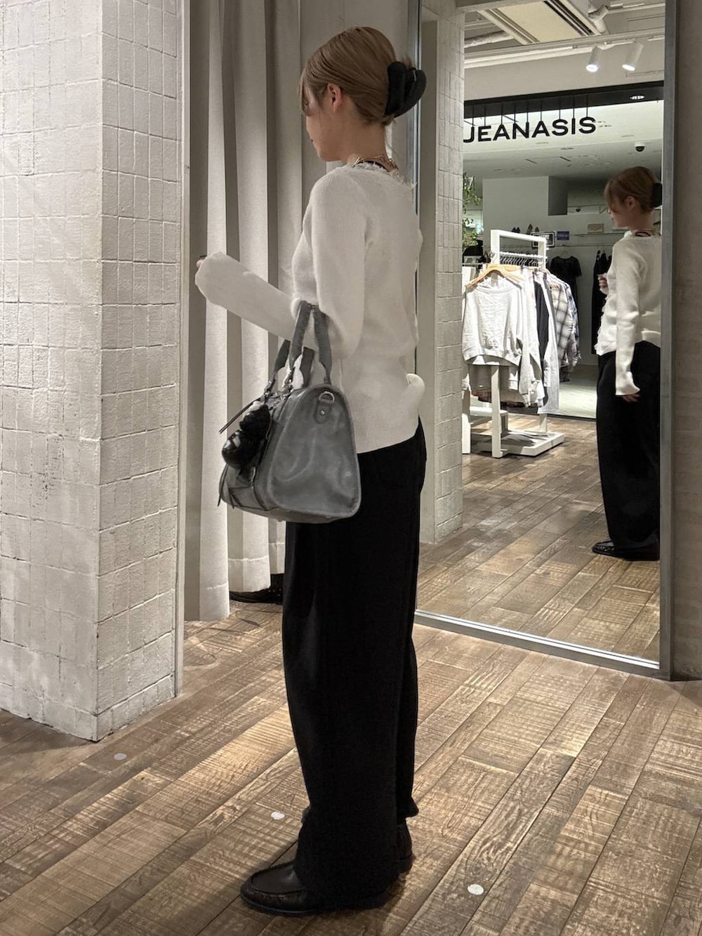 ブラウン系のローファー、ブルー系のボストンバッグ、ブラック系のスウェットパンツを着用したレディースの春コーディネートの2枚目の写真