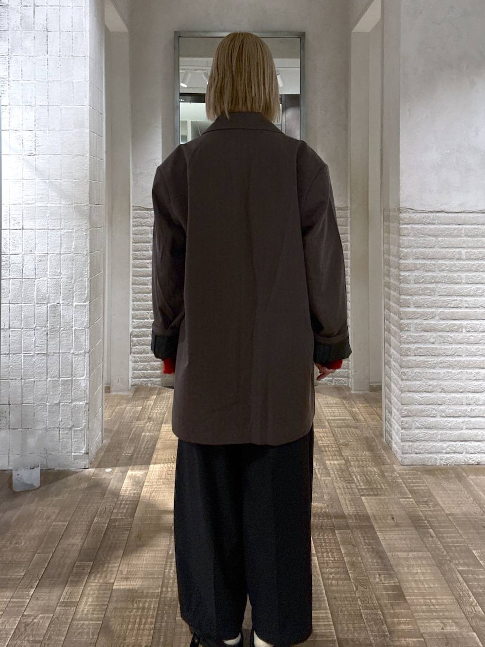 グレー系のテーラードジャケット、ブラック系のスラックス、レッド系のカーディガン/ボレロを着用したレディースの秋コーディネートの3枚目の写真