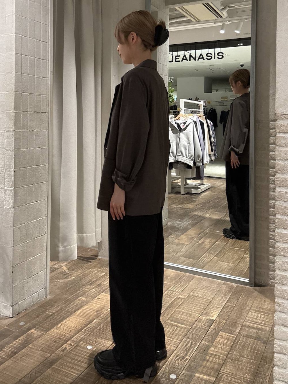 ブラック系のローファー、ブラック系のデニムパンツ、ブラウン系のテーラードジャケットを着用したレディースの春コーディネートの2枚目の写真