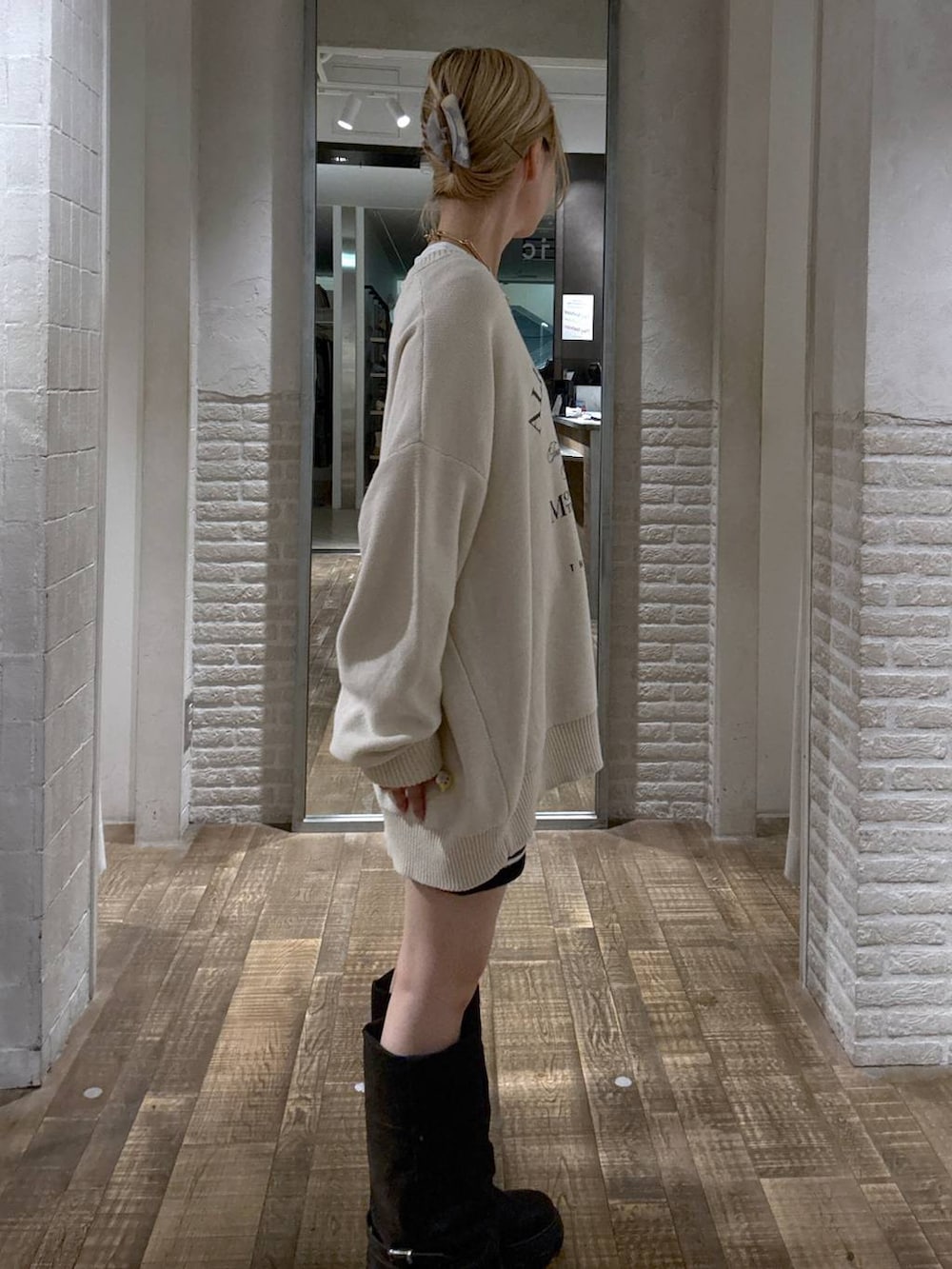 ブラック系のブーツ、ホワイト系のニット/セーターを着用したレディースの秋コーディネートの2枚目の写真