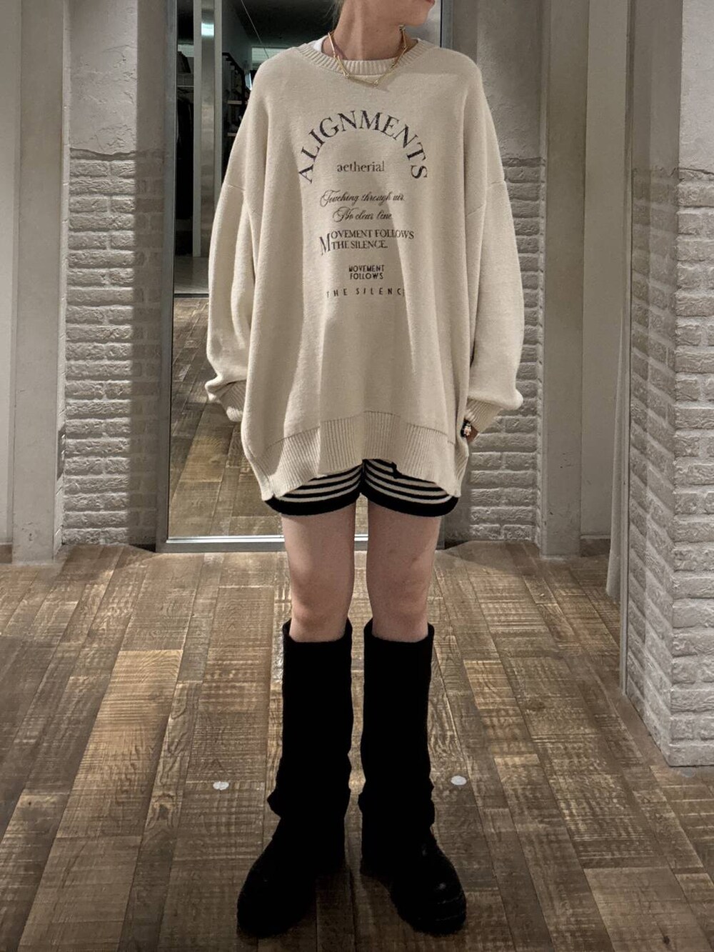 ブラック系のブーツ、ホワイト系のニット/セーターを着用したレディースの秋コーディネートの4枚目の写真