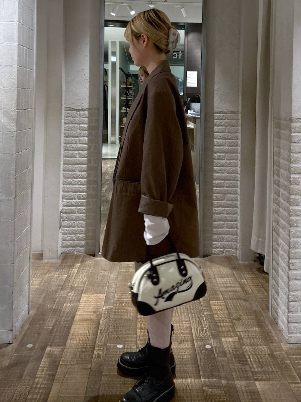 グレー系のテーラードジャケット、ホワイト系のショルダーバッグ、ホワイト系のTシャツ/カットソーを着用したレディースの秋コーディネートの2枚目の写真