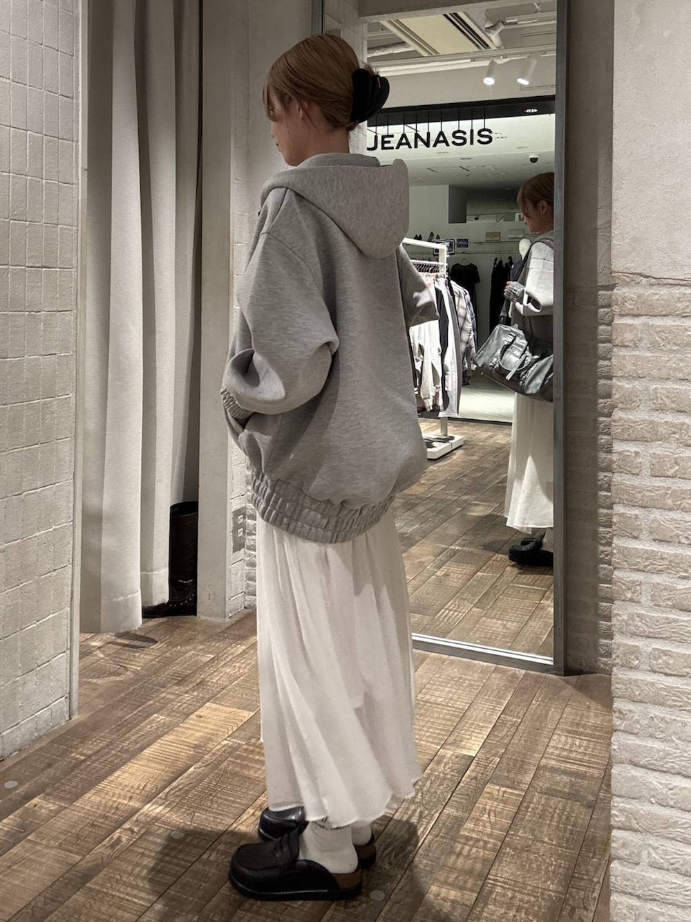 グレー系のブルゾン、ブラック系のローファー、ブルー系のボストンバッグを着用したレディースの春コーディネートの2枚目の写真