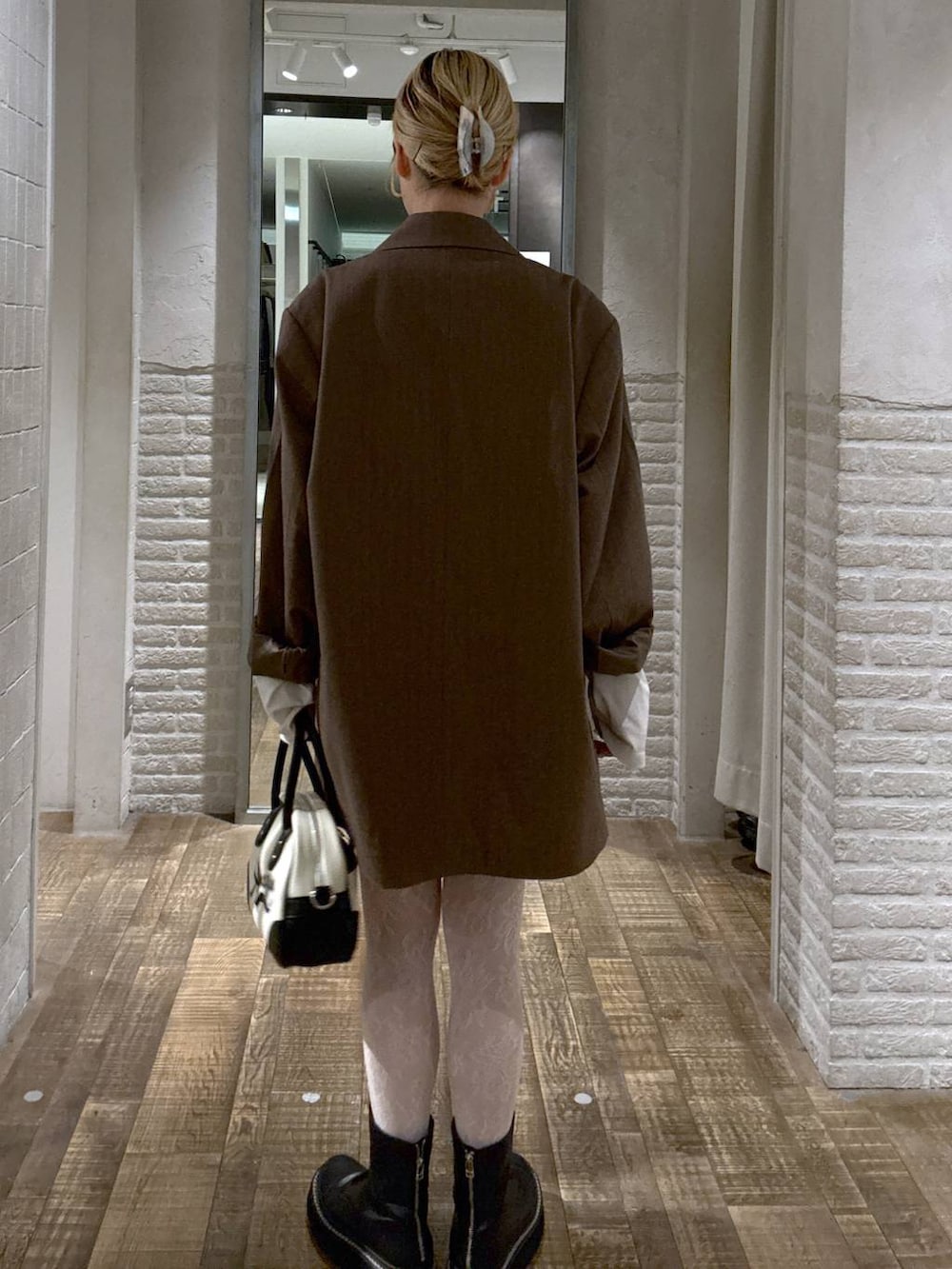 グレー系のテーラードジャケット、ホワイト系のショルダーバッグ、ホワイト系のTシャツ/カットソーを着用したレディースの秋コーディネートの3枚目の写真